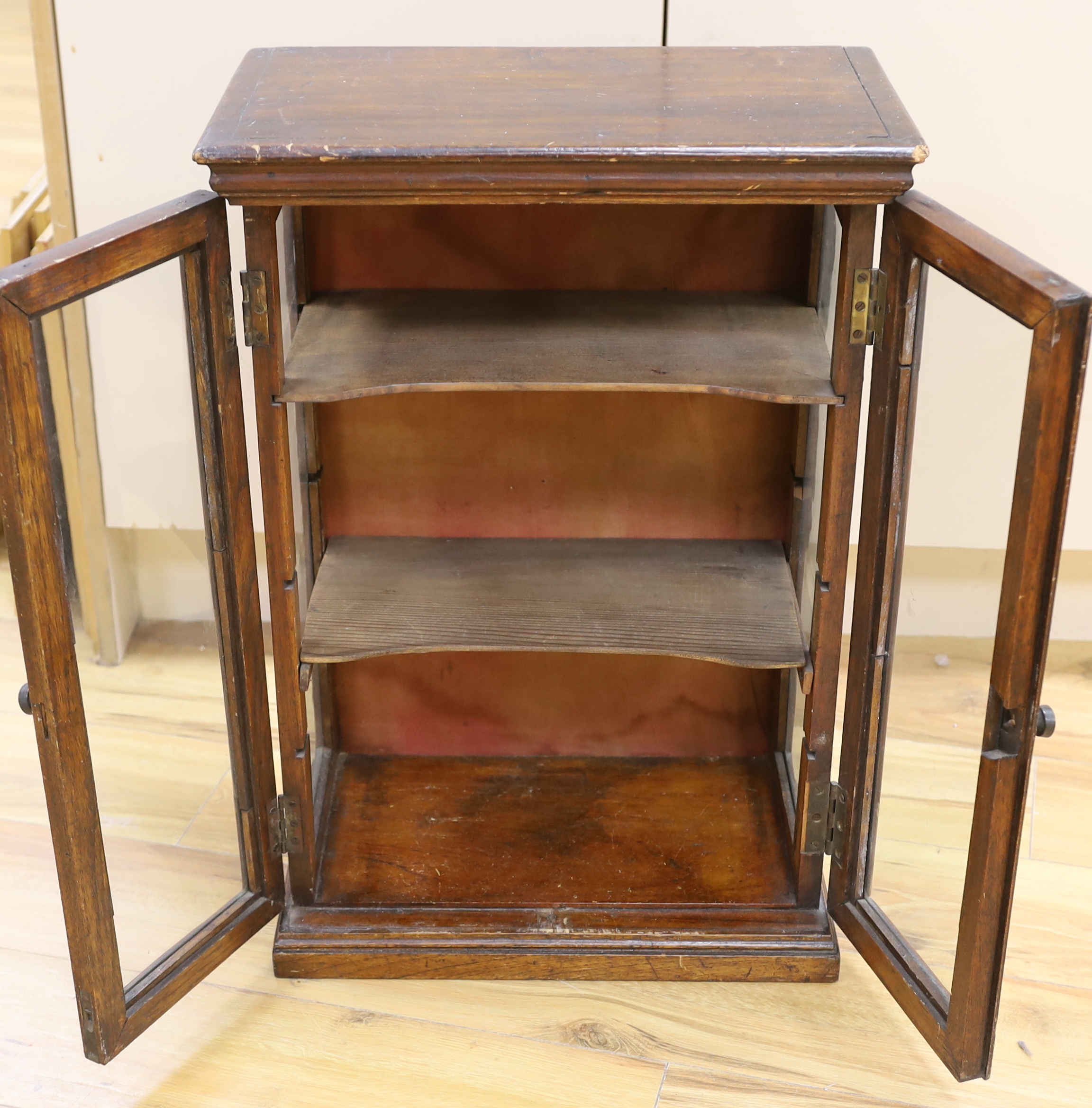 A small early 20th century glazed oak and pine two door shop display cabinet, 65.5 x 45 x 26cm